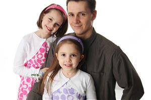 Father and two daughters dressed in nice clothes.